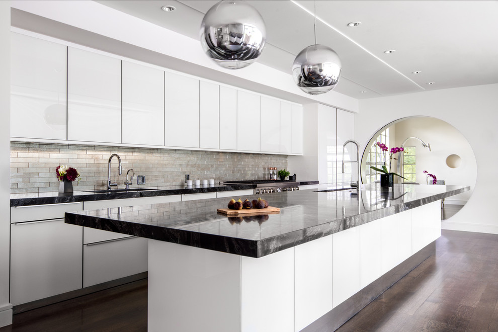 Inspiration for a contemporary galley kitchen in Austin with flat-panel cabinets, white cabinets, metallic splashback, metal splashback, stainless steel appliances, dark hardwood floors and with island.