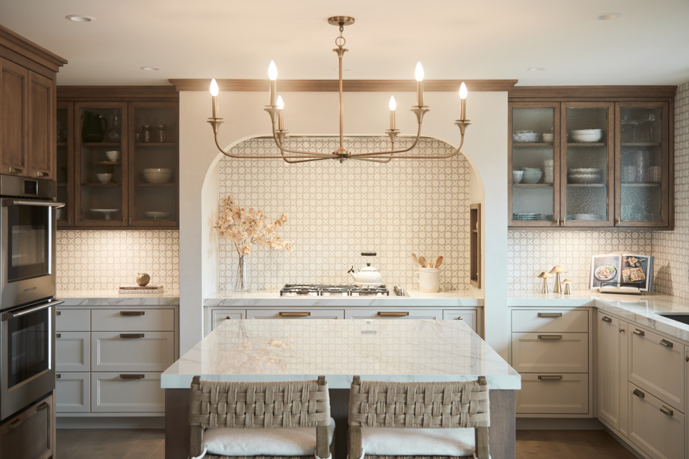 Mid-sized transitional u-shaped medium tone wood floor and brown floor eat-in kitchen photo with an undermount sink, glass-front cabinets, medium tone wood cabinets, solid surface countertops, yellow backsplash, mosaic tile backsplash, paneled appliances, an island and white countertops