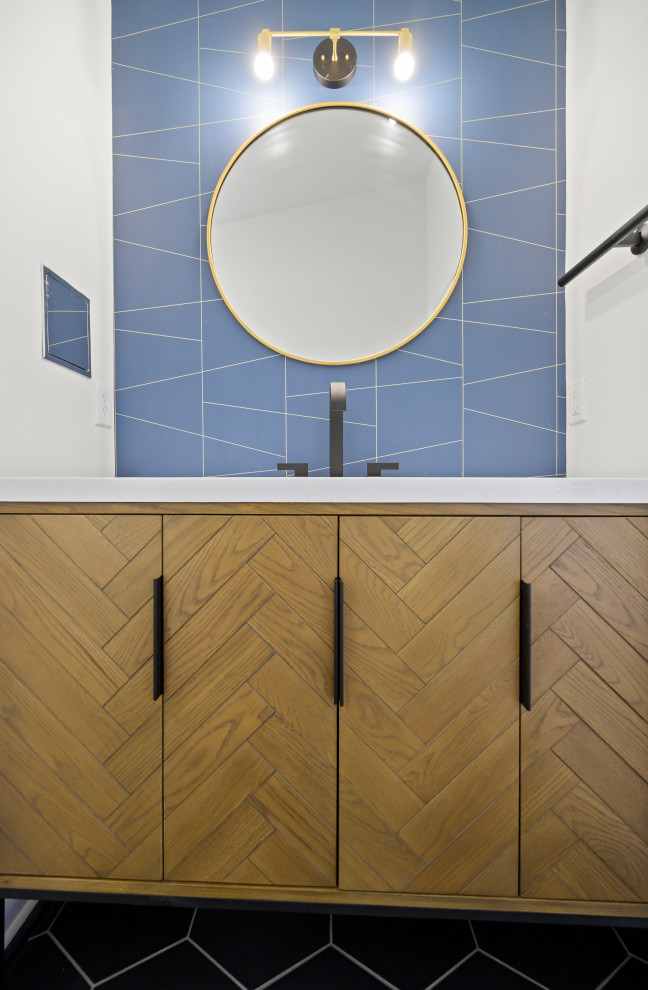 This is an example of a small midcentury master bathroom in Birmingham with furniture-like cabinets, light wood cabinets, an alcove shower, a one-piece toilet, white walls, porcelain floors, an integrated sink, solid surface benchtops, black floor, a hinged shower door, white benchtops, a niche, a single vanity, a freestanding vanity, vaulted and wallpaper.