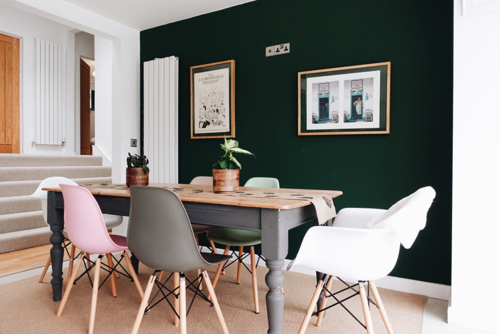 Mid-sized scandinavian dining room in West Midlands with green walls, carpet and beige floor.