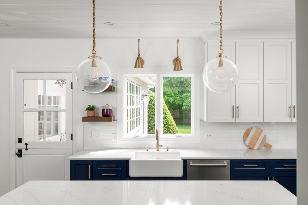 Inspiration for a large country l-shaped eat-in kitchen in Boston with a farmhouse sink, shaker cabinets, white cabinets, marble benchtops, white splashback, porcelain splashback, stainless steel appliances, medium hardwood floors, with island, brown floor and white benchtop.
