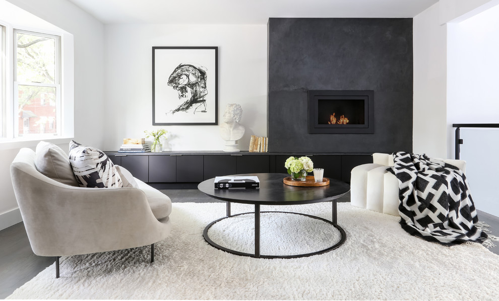 Contemporary living room in New York with white walls, dark hardwood floors, a standard fireplace and grey floor.