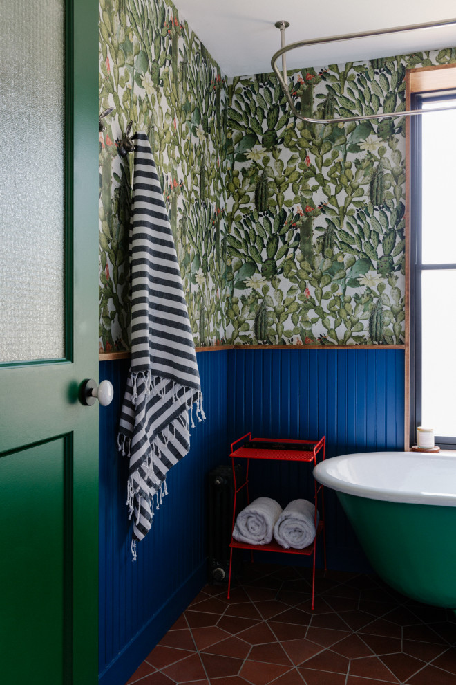 Example of an eclectic ceramic tile, brown floor and single-sink claw-foot bathtub design in New York