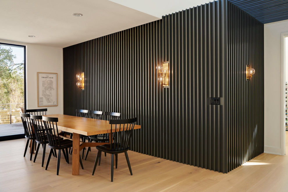 Idee per una sala da pranzo aperta verso la cucina minimalista di medie dimensioni con pareti grigie, parquet chiaro e pannellatura