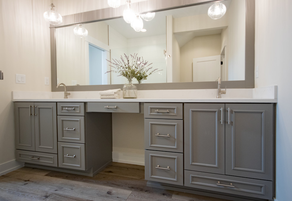 Design ideas for a master bathroom in Grand Rapids with raised-panel cabinets, grey cabinets, an alcove shower, a bidet, beige walls, vinyl floors, an undermount sink, engineered quartz benchtops, brown floor, a hinged shower door and white benchtops.