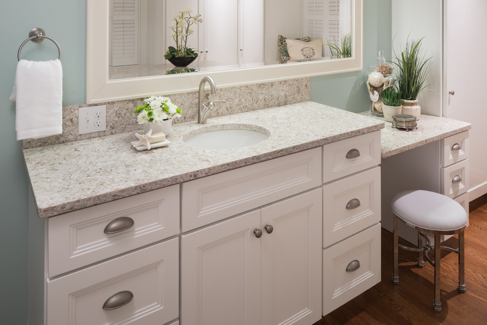 Mid-sized beach style master bathroom in Boston with recessed-panel cabinets, white cabinets, an alcove shower, blue walls, medium hardwood floors, an undermount sink, granite benchtops, brown floor and a hinged shower door.