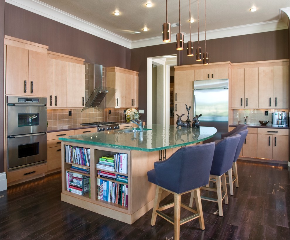 Mid-sized contemporary l-shaped open plan kitchen in Sacramento with stainless steel appliances, an undermount sink, flat-panel cabinets, glass benchtops, light wood cabinets, beige splashback, glass tile splashback, dark hardwood floors, with island and turquoise benchtop.