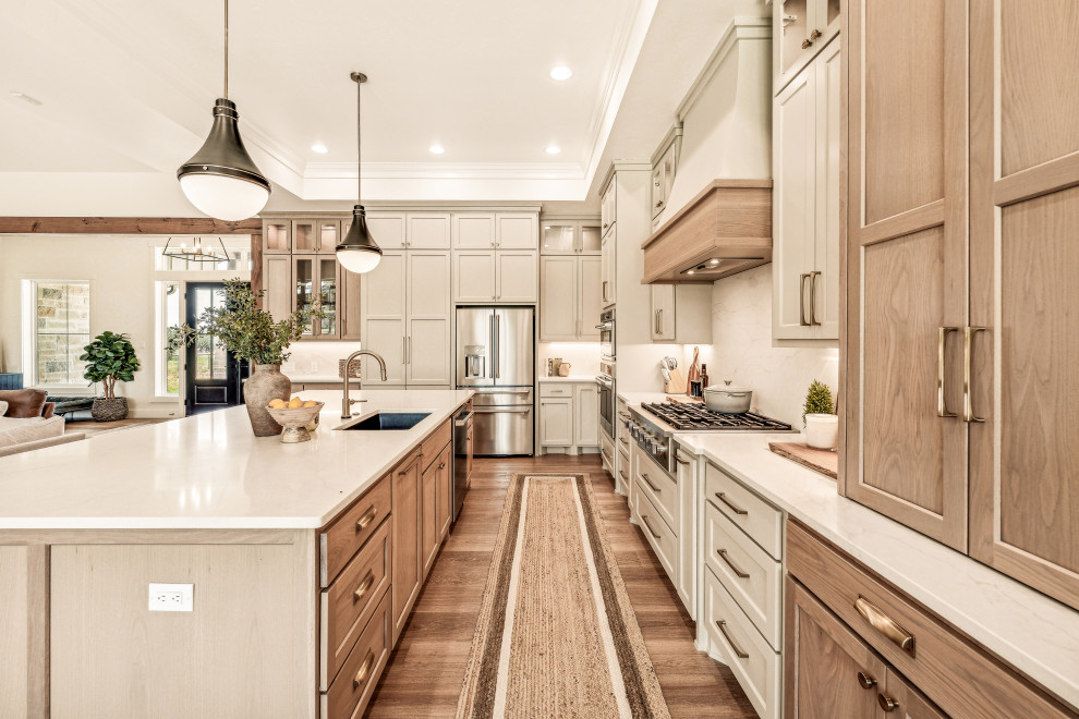 Example of a mid-sized transitional l-shaped vinyl floor and tray ceiling eat-in kitchen design in Dallas with an undermount sink, shaker cabinets, light wood cabinets, quartz countertops, white backsplash, quartz backsplash, stainless steel appliances, an island and white countertops