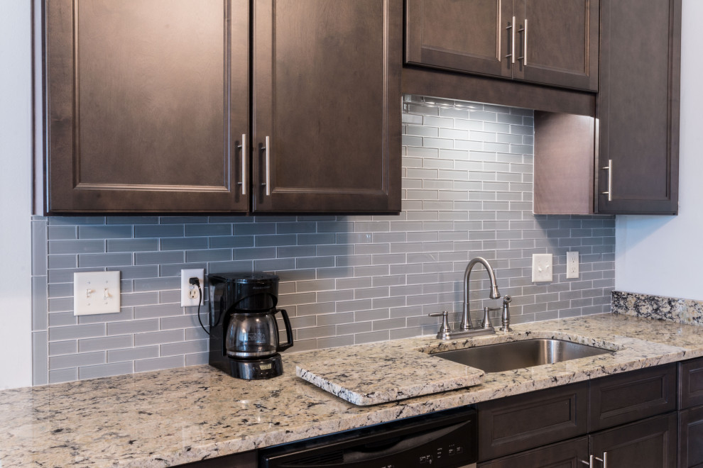 Small galley cement tile floor and beige floor eat-in kitchen photo with an undermount sink, flat-panel cabinets, gray cabinets, granite countertops, gray backsplash, glass tile backsplash, stainless steel appliances, no island and white countertops