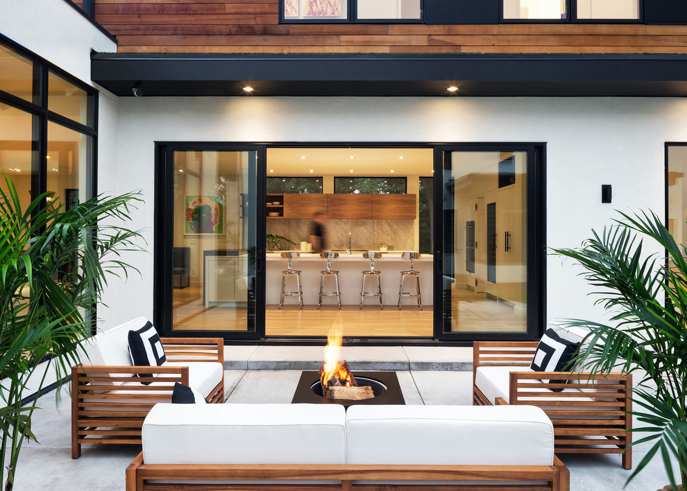 This is an example of a large contemporary patio in Minneapolis with concrete slab, no cover and a fire feature.