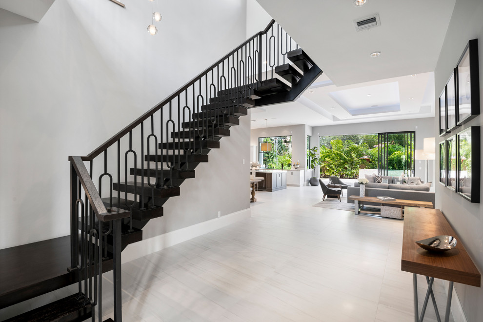 Photo of a large transitional wood floating staircase in Miami with wood railing.
