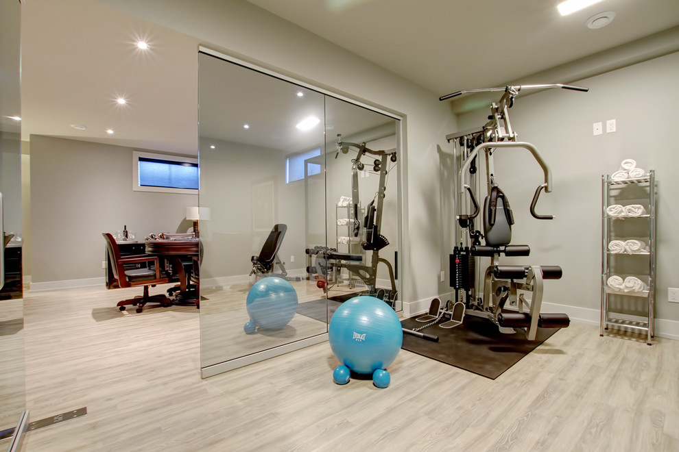 Inspiration for a small contemporary home weight room in Toronto with beige walls, light hardwood floors and beige floor.