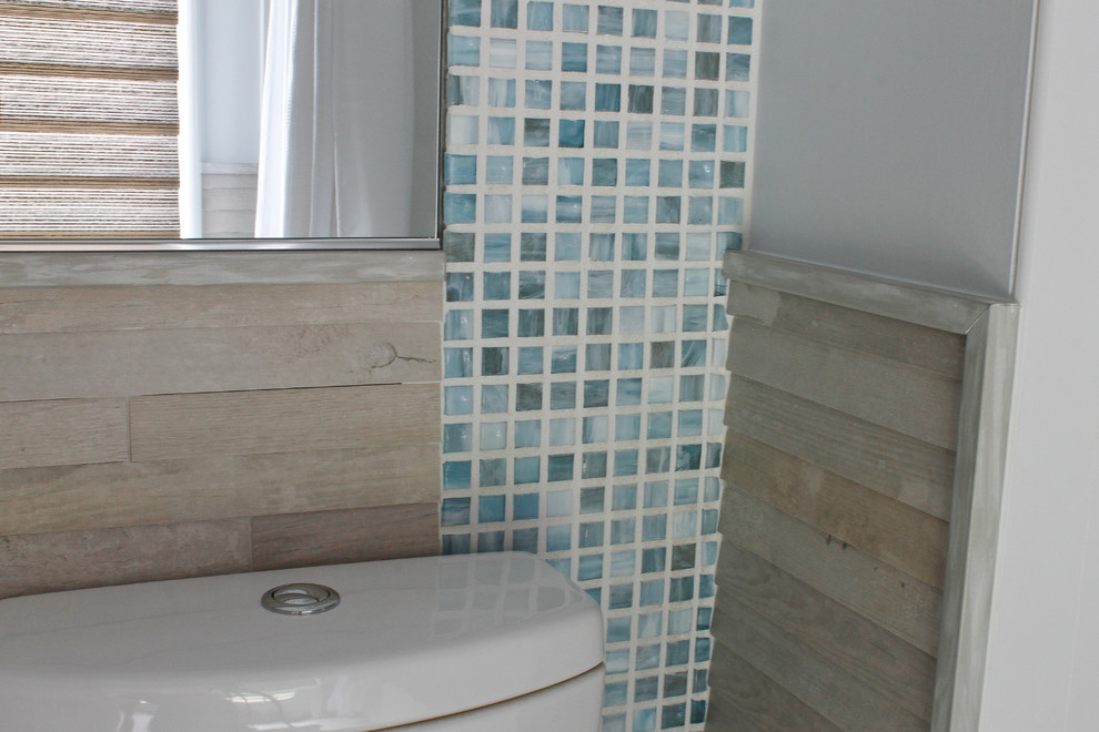 Inspiration for a large beach style kids bathroom in New York with a one-piece toilet, blue tile and glass tile.