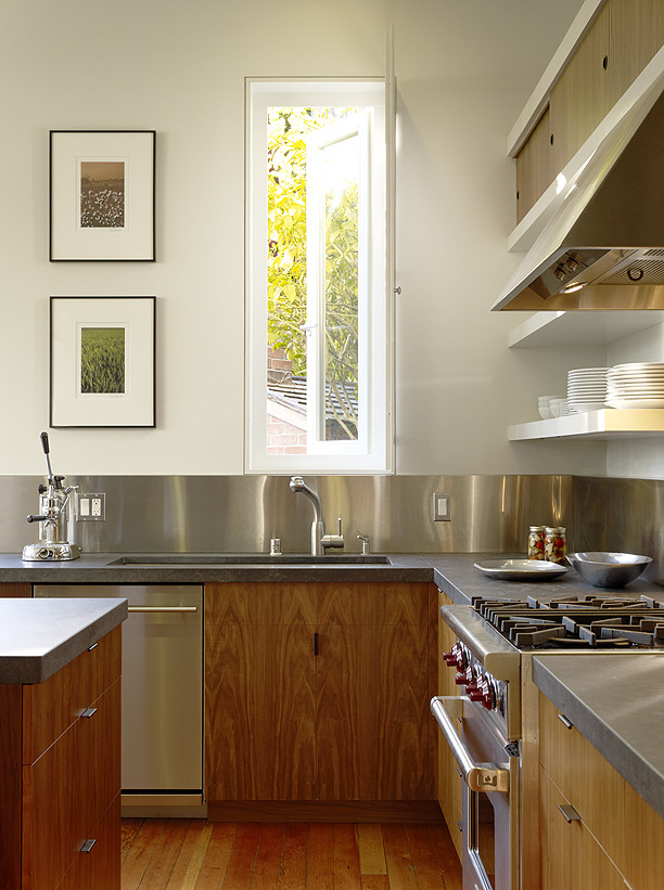 Inspiration for a modern l-shaped eat-in kitchen in San Francisco with flat-panel cabinets, metallic splashback, metal splashback, stainless steel appliances, light wood cabinets, soapstone benchtops and light hardwood floors.