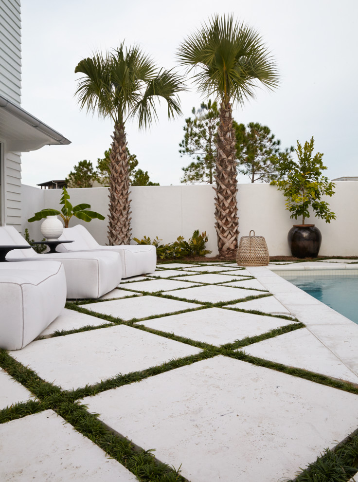 This is an example of a mid-sized contemporary backyard rectangular lap pool in Miami with concrete pavers.