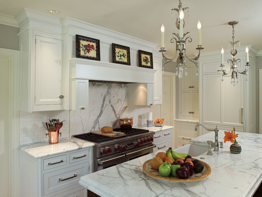 Example of a mid-sized transitional u-shaped dark wood floor eat-in kitchen design in Chicago with a farmhouse sink, beaded inset cabinets, white cabinets, white backsplash, subway tile backsplash, stainless steel appliances, an island and marble countertops