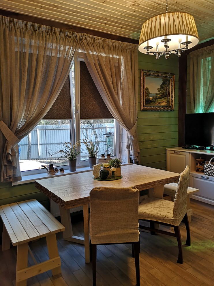 This is an example of a small country dining room in Moscow with green walls, porcelain floors and beige floor.