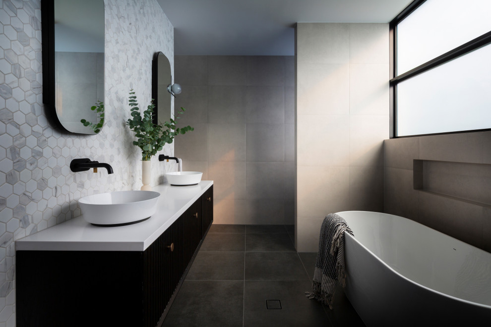 Design ideas for a mid-sized modern bathroom in Canberra - Queanbeyan with furniture-like cabinets, dark wood cabinets, a wall-mount toilet, black and white tile, porcelain tile, porcelain floors, a vessel sink, engineered quartz benchtops, grey floor, grey benchtops and a built-in vanity.