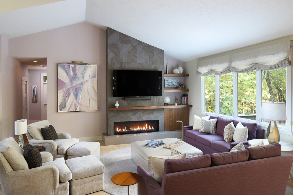 This is an example of a mid-sized transitional open concept living room in Grand Rapids with light hardwood floors, a ribbon fireplace, a tile fireplace surround, a wall-mounted tv, pink walls and beige floor.