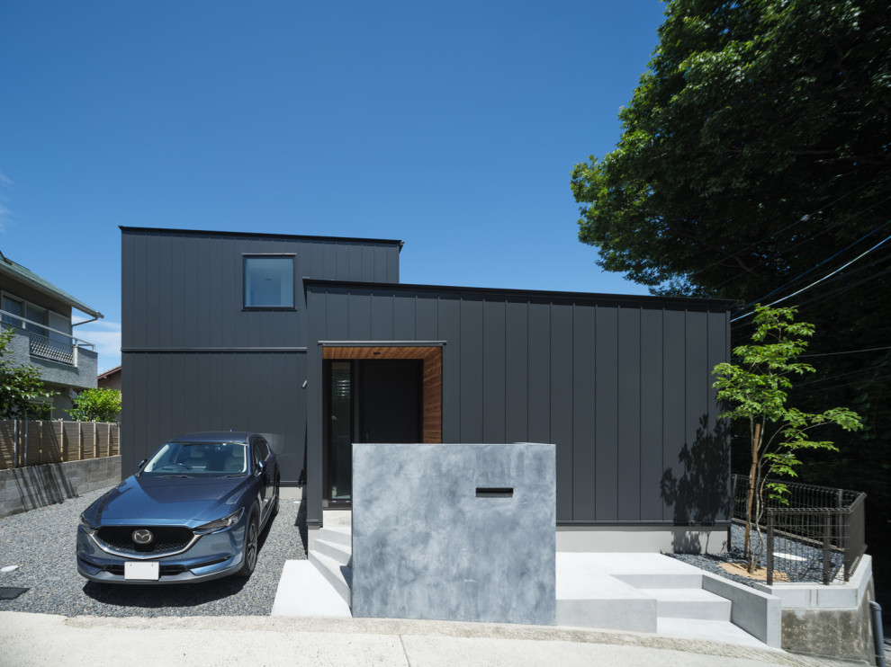 Esempio della casa con tetto a falda unica nero industriale con copertura in metallo o lamiera e tetto nero