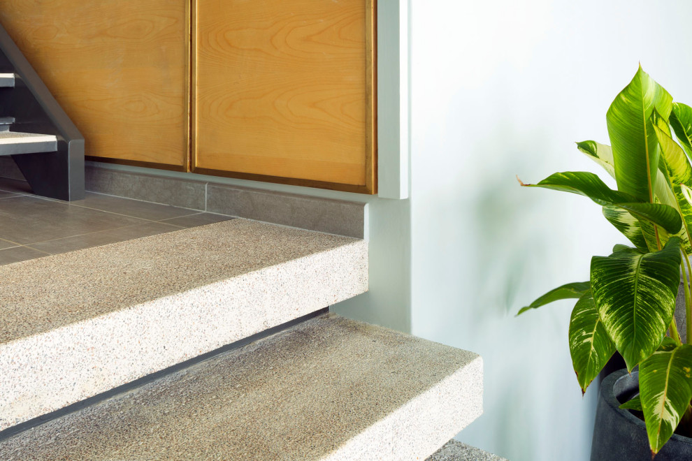 Mid-sized modern concrete straight staircase in Other with concrete risers and metal railing.