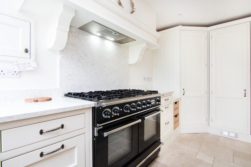 Photo of a mid-sized traditional u-shaped eat-in kitchen in Essex with a farmhouse sink, shaker cabinets, white cabinets, terra-cotta floors, with island, beige floor, marble benchtops and grey splashback.