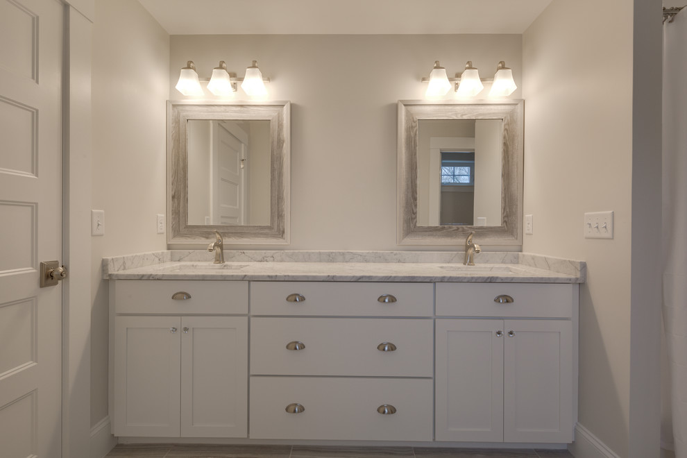 Large bathroom in Boston with shaker cabinets, white cabinets, light hardwood floors and yellow floor.