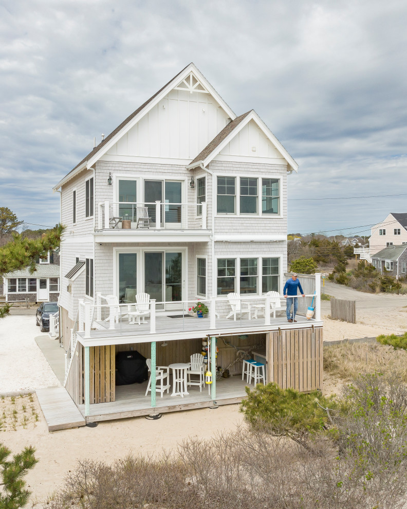 Foto de fachada de casa costera de dos plantas con revestimientos combinados, tejado de teja de madera y panel y listón