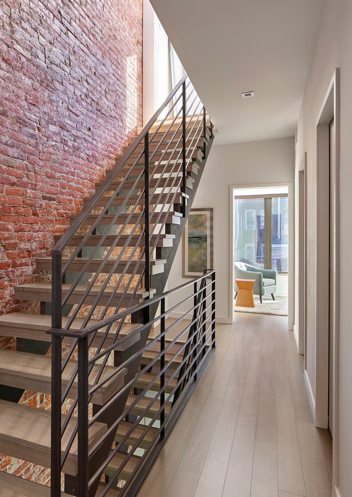 Design ideas for a mid-sized industrial wood straight staircase in Philadelphia with open risers and metal railing.