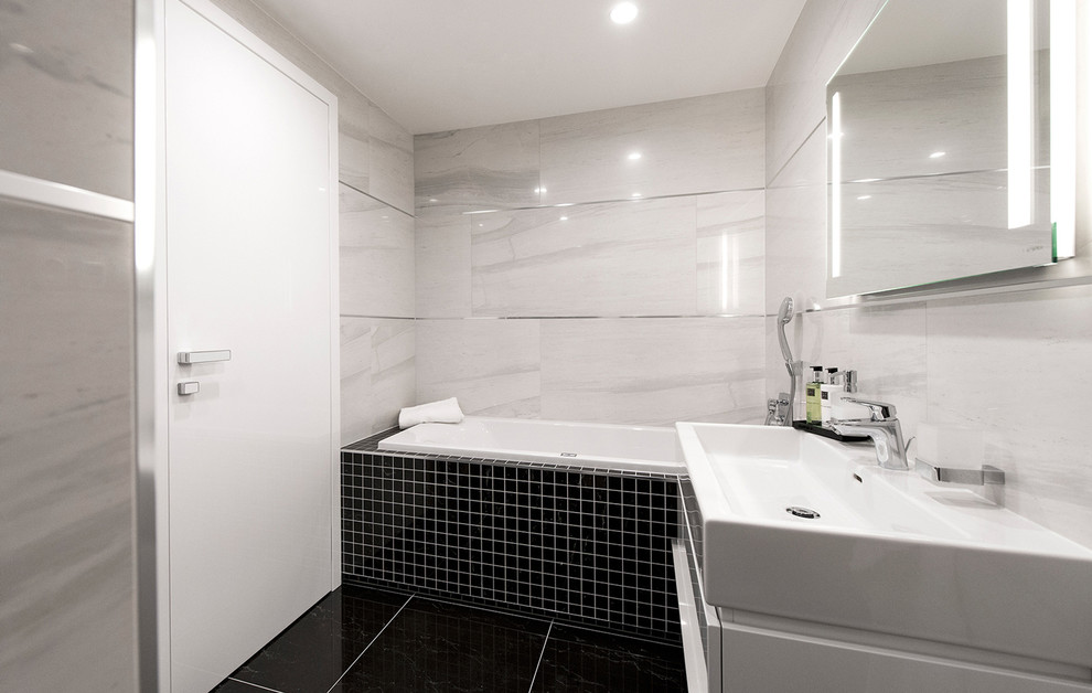 Small contemporary master bathroom in Other with flat-panel cabinets, white cabinets, an alcove tub, a shower/bathtub combo, gray tile, porcelain tile, porcelain floors and an integrated sink.