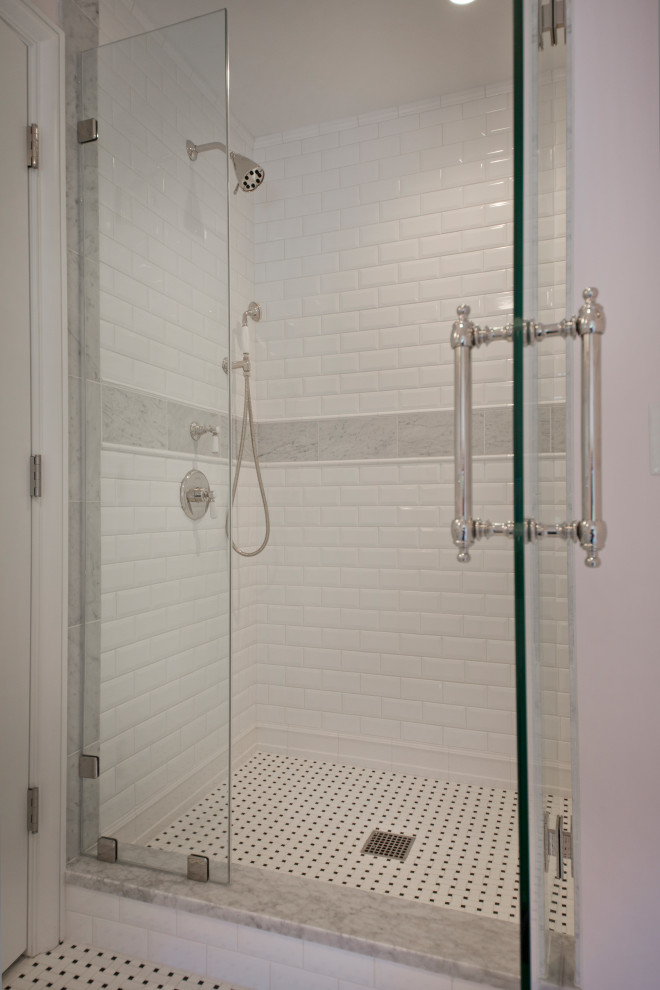 Foto på ett stort vintage vit badrum med dusch, med luckor med profilerade fronter, vita skåp, en dusch i en alkov, vit kakel, tunnelbanekakel, rosa väggar, marmorbänkskiva, vitt golv och dusch med gångjärnsdörr