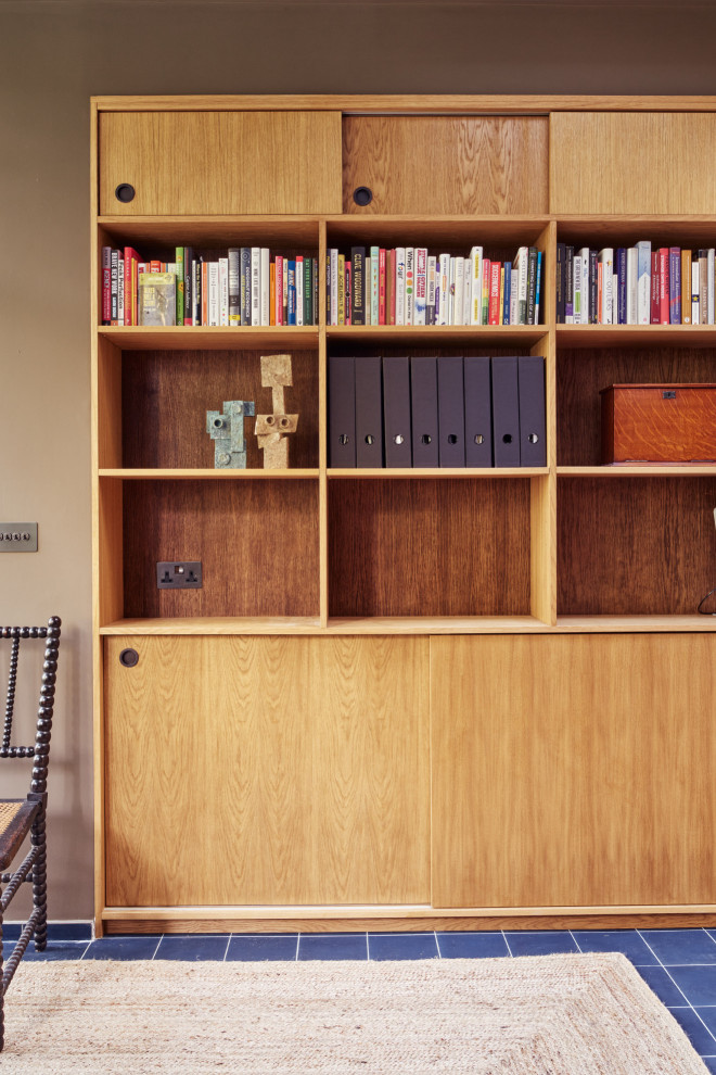 Mittelgroßes Uriges Arbeitszimmer mit Arbeitsplatz, brauner Wandfarbe, Betonboden, freistehendem Schreibtisch und blauem Boden in London