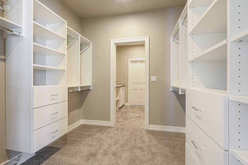 Example of a mid-sized transitional gender-neutral carpeted and beige floor walk-in closet design with flat-panel cabinets and white cabinets