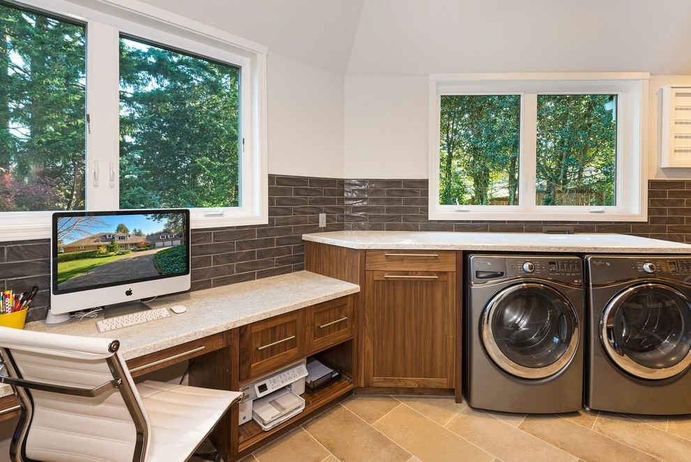 Inspiration for a large transitional utility room in Seattle with an undermount sink, shaker cabinets, medium wood cabinets, limestone benchtops, grey walls, porcelain floors, a side-by-side washer and dryer, beige floor and beige benchtop.
