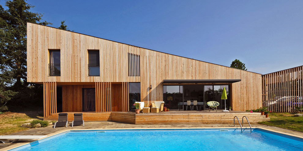 This is an example of a mid-sized contemporary exterior in Lyon with a shed roof and wood siding.