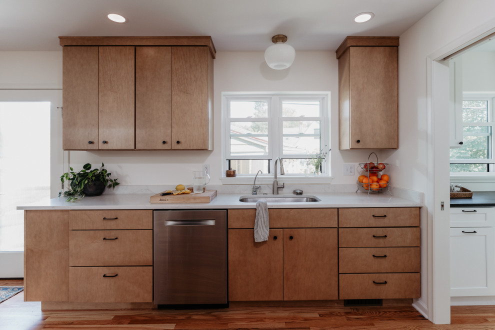 Kitchen pantry - mid-sized 1960s l-shaped medium tone wood floor kitchen pantry idea in Detroit with an undermount sink, flat-panel cabinets, light wood cabinets, quartz countertops, white backsplash, quartz backsplash, stainless steel appliances, a peninsula and white countertops