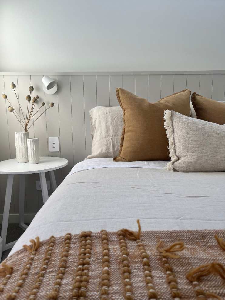 Imagen de habitación de invitados actual de tamaño medio con paredes blancas, moqueta, suelo gris y panelado