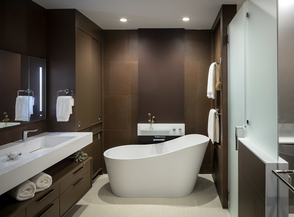 Design ideas for a mid-sized contemporary master bathroom in San Francisco with flat-panel cabinets, brown cabinets, a curbless shower, brown tile, ceramic tile, brown walls, ceramic floors, an integrated sink, a freestanding tub and a hinged shower door.