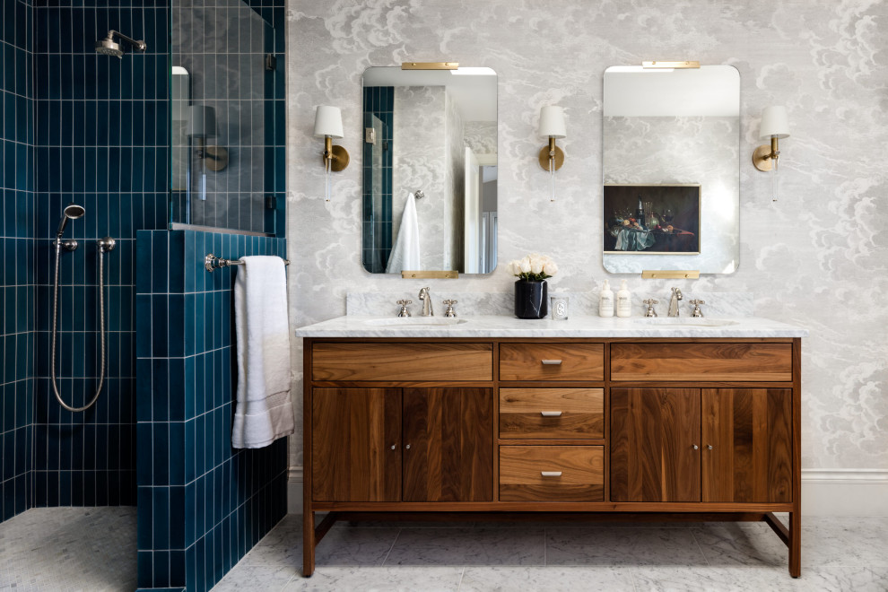 Photo of a large transitional master bathroom in Seattle with furniture-like cabinets, brown cabinets, a freestanding tub, an alcove shower, blue tile, cement tile, grey walls, marble floors, an undermount sink, marble benchtops, grey floor, a hinged shower door, grey benchtops, a shower seat, a double vanity, a freestanding vanity and wallpaper.