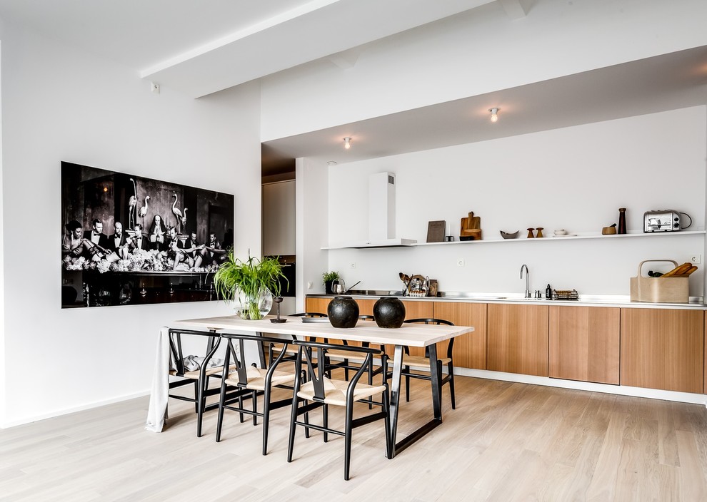 Photo of a large contemporary single-wall kitchen in Stockholm with flat-panel cabinets, medium wood cabinets, white splashback, stainless steel appliances, light hardwood floors and brown floor.