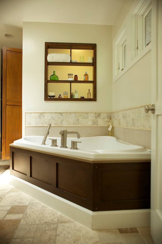 This is an example of a transitional bathroom in Los Angeles with a vessel sink, recessed-panel cabinets, medium wood cabinets, engineered quartz benchtops, a corner tub, a corner shower, beige tile and stone tile.