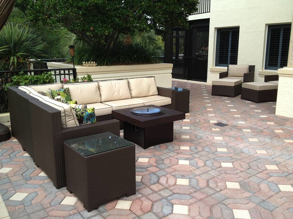 Example of a large classic backyard brick patio design in Orlando with a fire pit