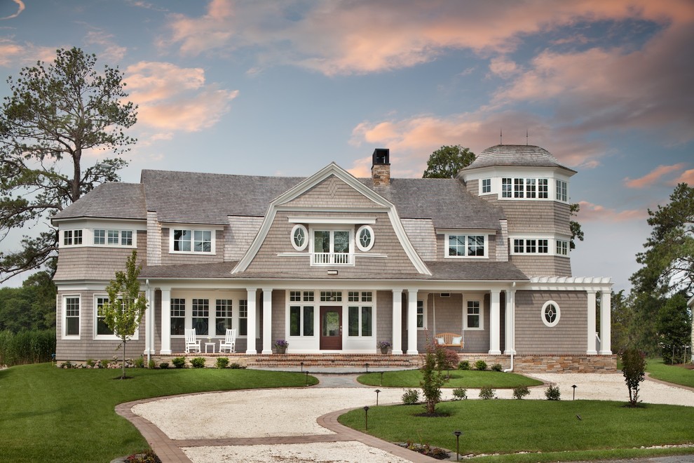Photo of a large beach style three-storey beige exterior in DC Metro with wood siding and a gambrel roof.