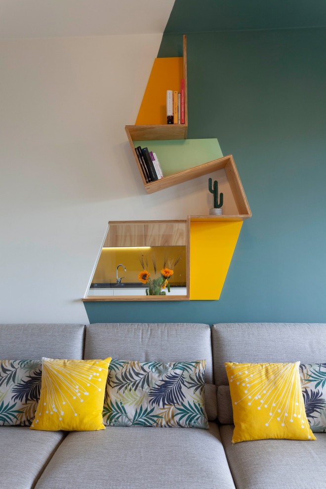 Immagine di un ampio soggiorno nordico aperto con libreria, pareti blu, pavimento con piastrelle in ceramica, nessun camino, TV a parete, pavimento beige e pannellatura