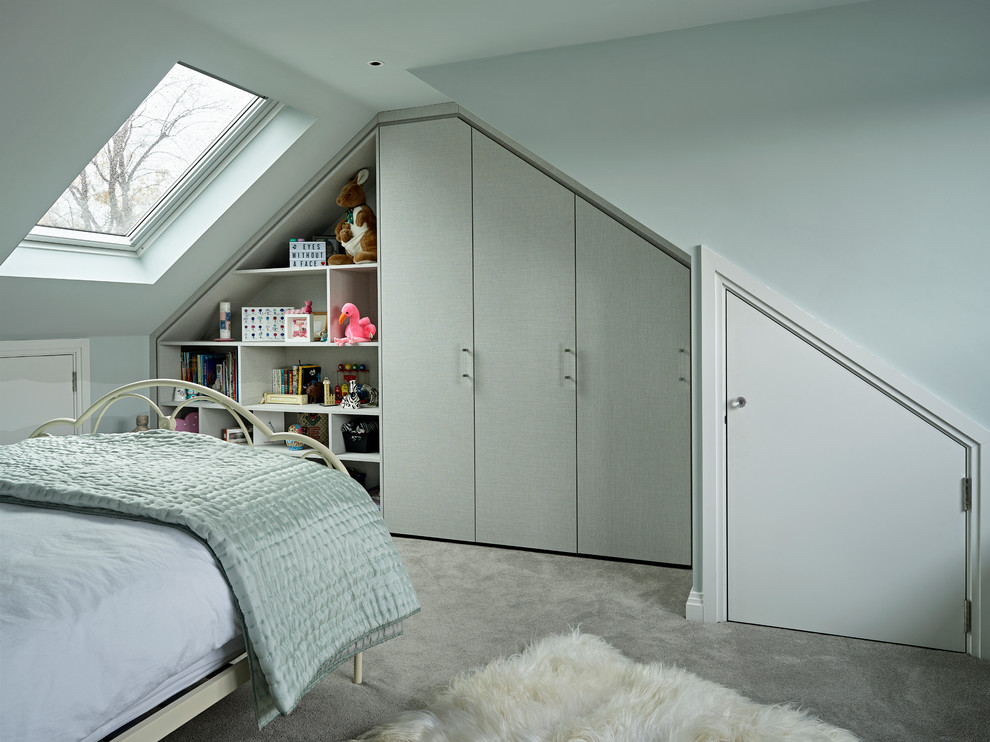 Mid-sized contemporary kids' bedroom in London with blue walls, carpet and grey floor for kids 4-10 years old and girls.