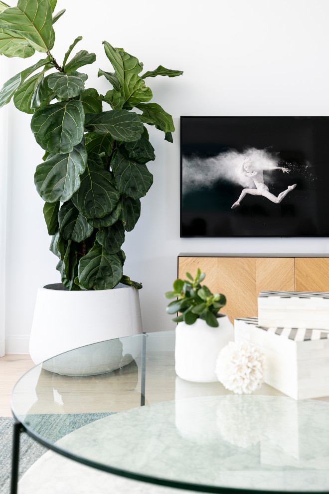Foto på ett stort funkis allrum med öppen planlösning, med vita väggar, ljust trägolv och en fristående TV