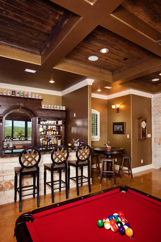Inspiration for a large traditional l-shaped home bar in Austin with dark wood cabinets.