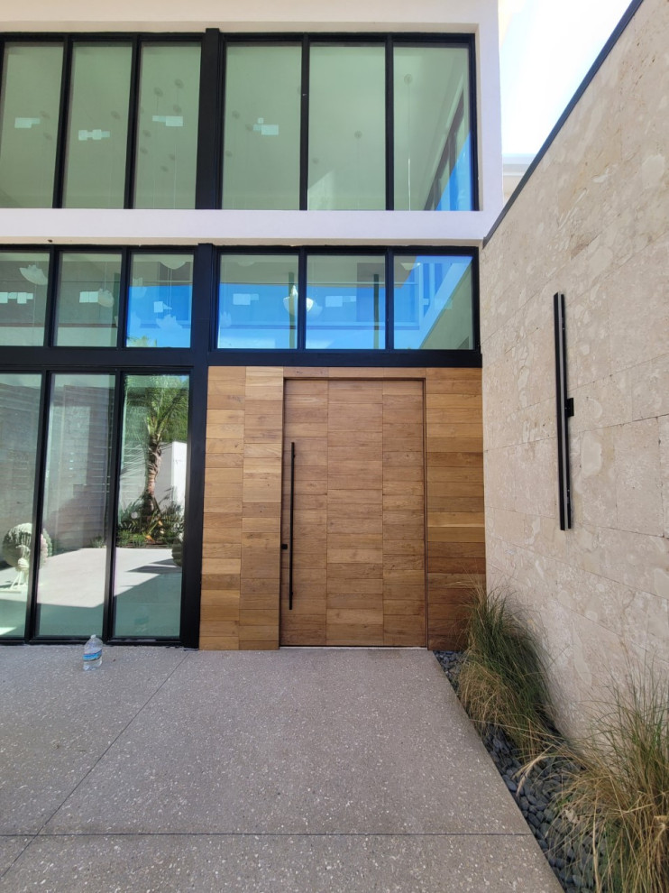 Großer Eingang mit Terrazzo-Boden, Drehtür und heller Holzhaustür in Tampa