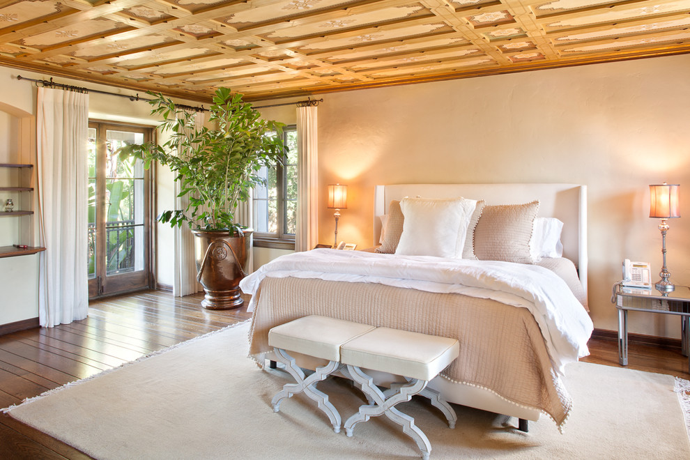 Inspiration for a master bedroom in Santa Barbara with beige walls and dark hardwood floors.