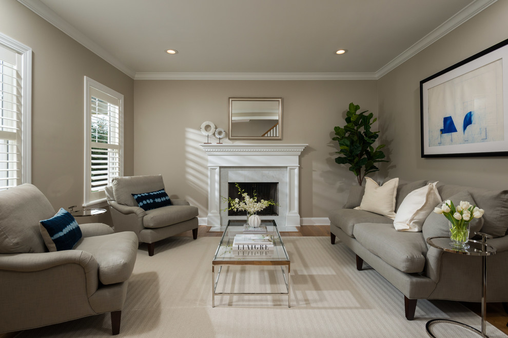 This is an example of a transitional enclosed living room in Boston with beige walls, medium hardwood floors, a standard fireplace, a stone fireplace surround and brown floor.